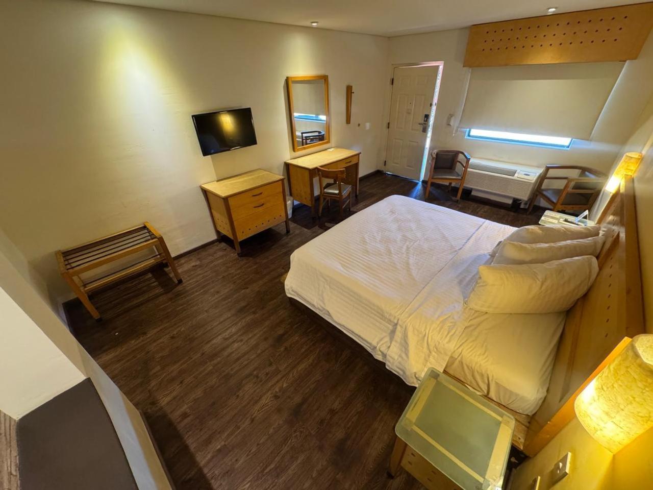 Habitación con cama extragrande y vistas a la piscina